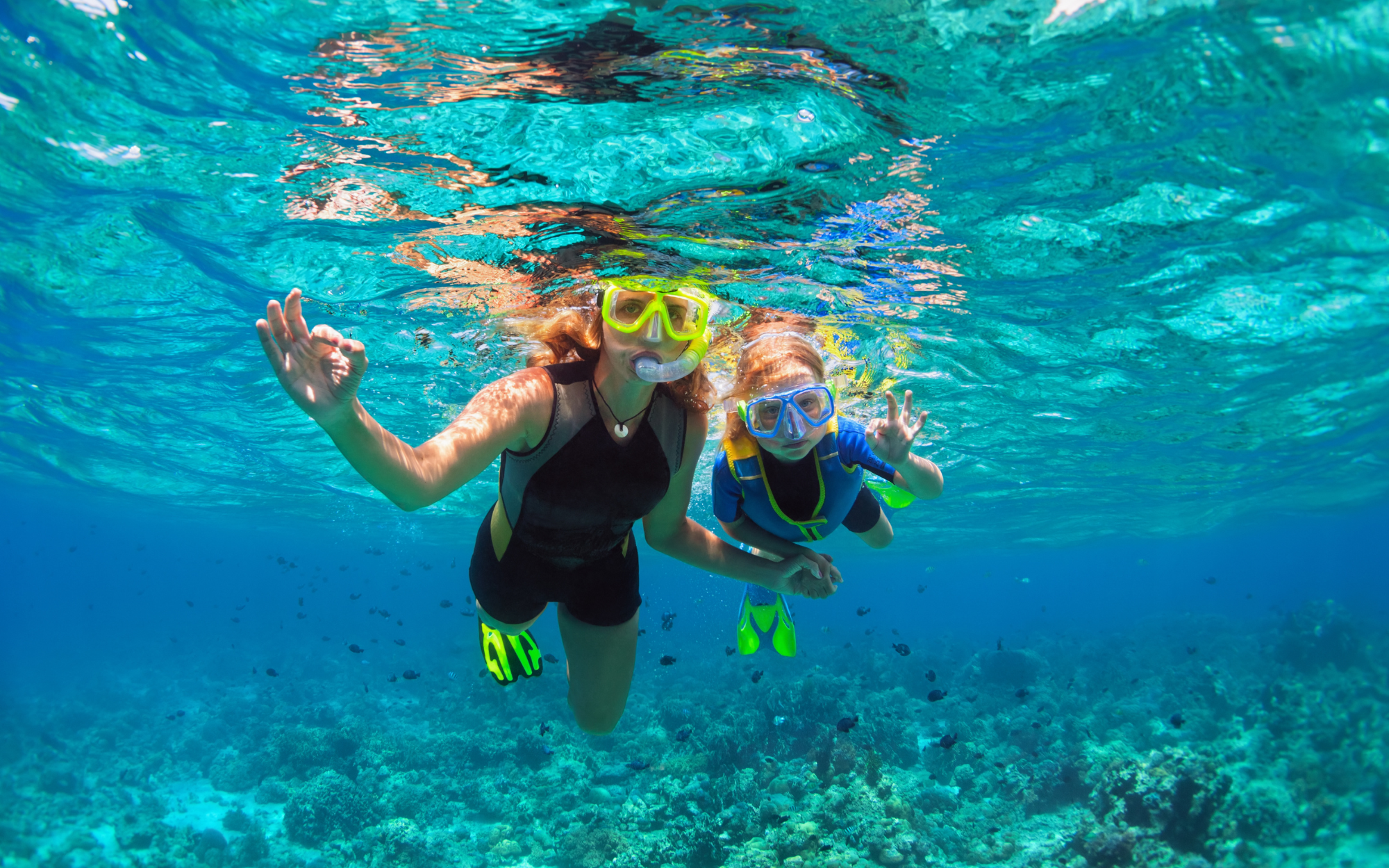 Mom and daughter snorkeling in clear water